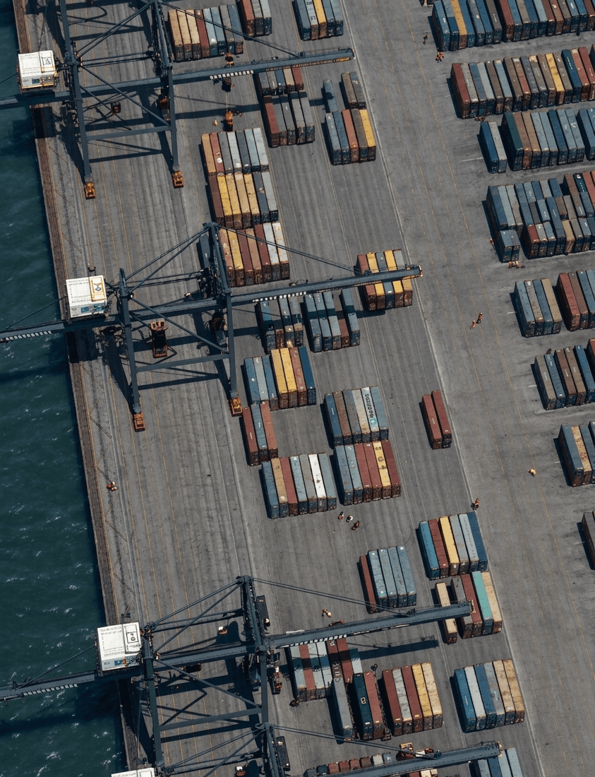 Aerial view of gantry cranes and stacked shipping containers at a port terminal